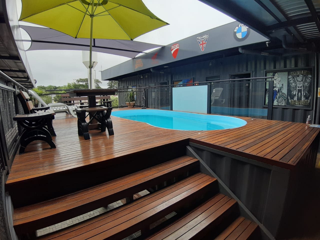 Piscina do MotoBox com deck, mesas e guarda-sóis